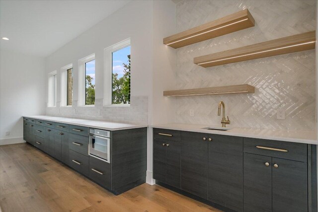 98 Wennmohs Pl, Horseshoe Bay, TX 78657 - kitchen featuring a sink, decorative backsplash, open shelves, and light wood finished floors