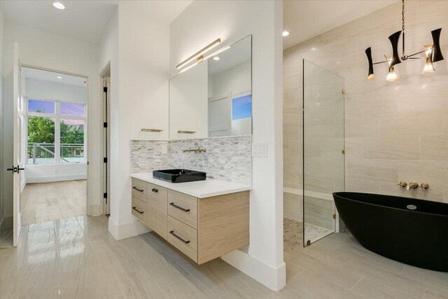 98 Wennmohs Pl, Horseshoe Bay, TX 78657 - full bathroom featuring a walk in shower, vanity, decorative backsplash, a freestanding bath, and recessed lighting