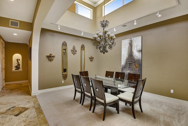 3211 Constitution Dr, Lago Vista, TX 78645 - dining space featuring a chandelier, track lighting, ornamental molding, light carpet, and arched walkways