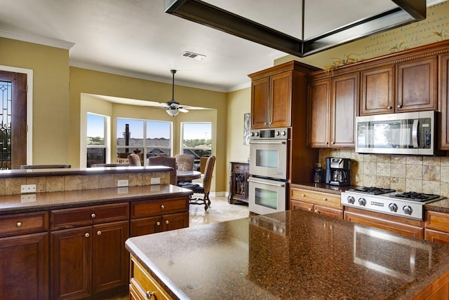 3211 Constitution Dr, Lago Vista, TX 78645 - kitchen with appliances with stainless steel finishes, backsplash, ornamental molding, ceiling fan, and dark stone counters