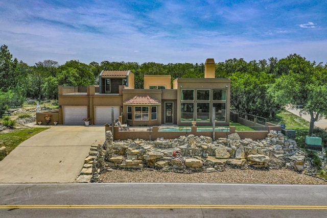3211 Constitution Dr, Lago Vista, TX 78645 - view of front of home featuring driveway, a chimney, stucco siding, a balcony, and a garage