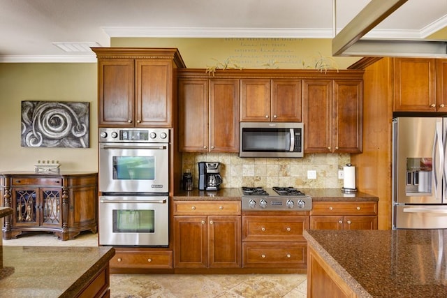 3211 Constitution Dr, Lago Vista, TX 78645 - kitchen featuring stainless steel appliances, backsplash, ornamental molding, dark stone counters, and brown cabinetry