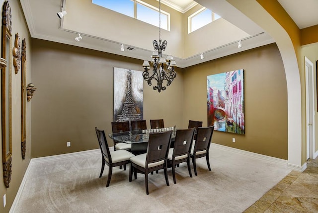 3211 Constitution Dr, Lago Vista, TX 78645 - dining space featuring rail lighting, a chandelier, light colored carpet, arched walkways, and ornamental molding