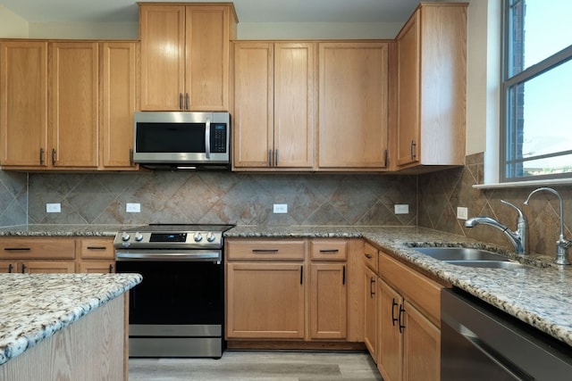 1244 Yellow Iris Rd, Leander, TX 78641 - kitchen featuring appliances with stainless steel finishes, light wood finished floors, light stone countertops, and backsplash