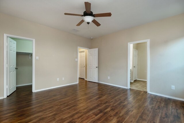1244 Yellow Iris Rd, Leander, TX 78641 - unfurnished bedroom with dark wood-type flooring, a walk in closet, and a ceiling fan