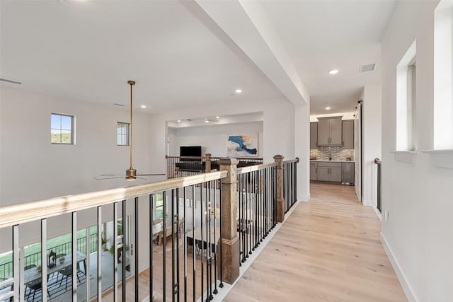 6901 Davenport Divide Rd, Austin, TX 78738 - corridor featuring light wood-type flooring, recessed lighting, baseboards, and an upstairs landing