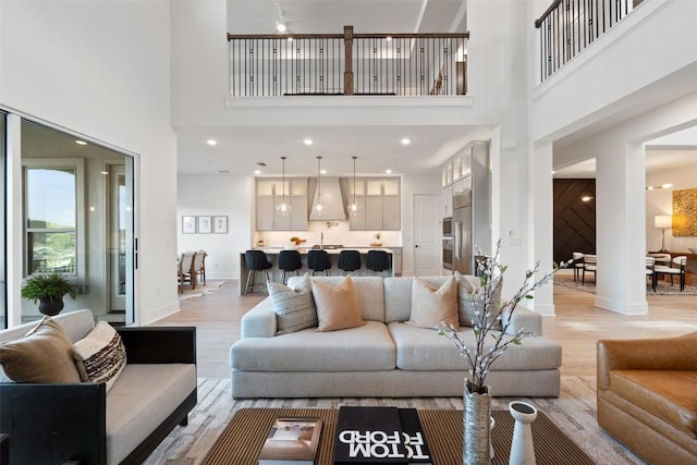 6901 Davenport Divide Rd, Austin, TX 78738 - living room featuring light wood-type flooring, a towering ceiling, baseboards, and a ceiling fan