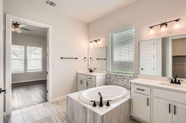461 Constitution Way, Kyle, TX 78640 - full bath featuring ceiling fan, healthy amount of natural light, two vanities, and a bath