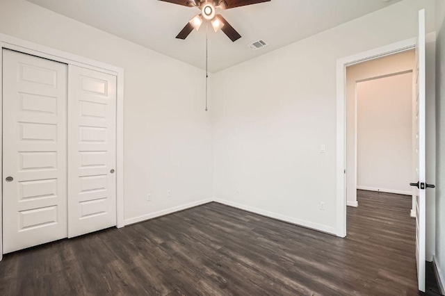 461 Constitution Way, Kyle, TX 78640 - unfurnished bedroom featuring dark wood-style flooring, baseboards, a closet, and a ceiling fan