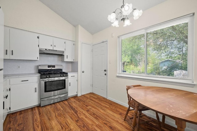 5808 Cedardale Dr, Austin, TX 78745 - kitchen featuring stainless steel gas range oven, vaulted ceiling, light countertops, under cabinet range hood, and dark wood finished floors