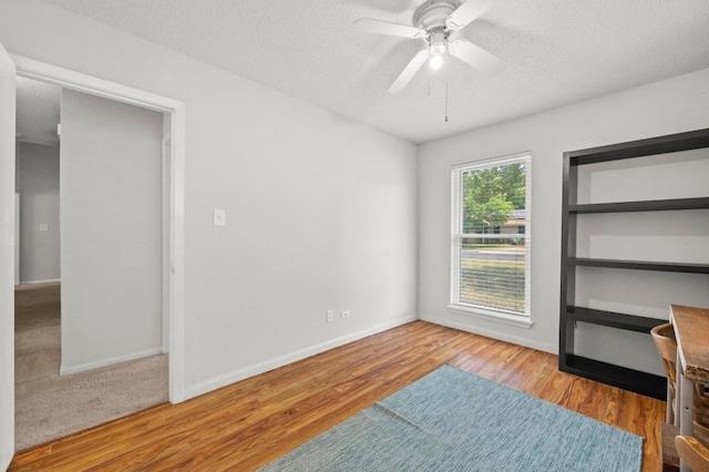 5808 Cedardale Dr, Austin, TX 78745 - unfurnished bedroom featuring wood finished floors, a textured ceiling, baseboards, and a ceiling fan