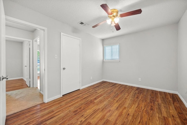 5808 Cedardale Dr, Austin, TX 78745 - unfurnished bedroom with wood finished floors, baseboards, ceiling fan, and a textured ceiling