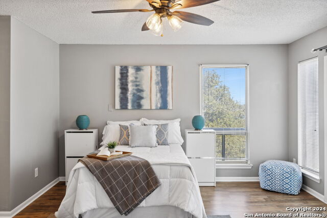 2918 Ranch Road 620th Rd N Unit C122, Austin, TX 78734 - bedroom featuring a textured ceiling, wood finished floors, multiple windows, baseboards, and ceiling fan