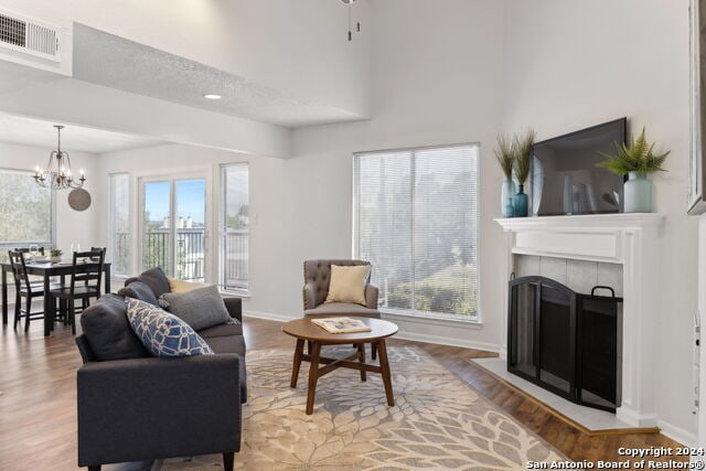 2918 Ranch Road 620th Rd N Unit C122, Austin, TX 78734 - living room with plenty of natural light, a chandelier, wood finished floors, a fireplace, and a high ceiling