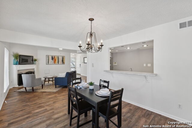 2918 Ranch Road 620th Rd N Unit C122, Austin, TX 78734 - dining area with dark wood-style floors, a fireplace, a chandelier, and baseboards