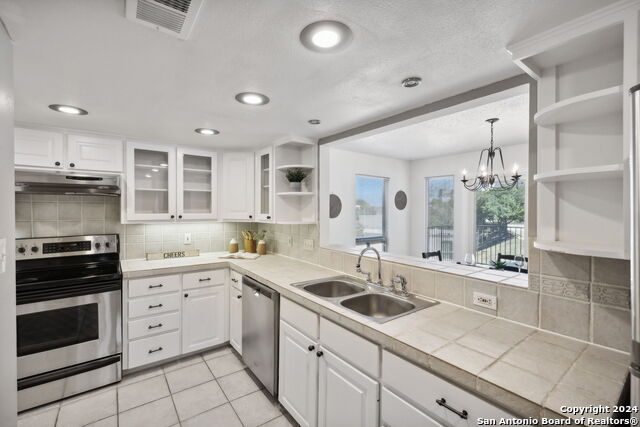 2918 Ranch Road 620th Rd N Unit C122, Austin, TX 78734 - kitchen with open shelves, stainless steel appliances, a sink, under cabinet range hood, and white cabinetry