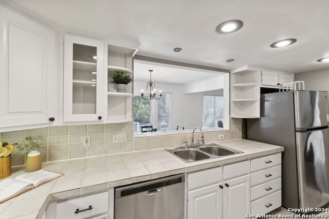 2918 Ranch Road 620th Rd N Unit C122, Austin, TX 78734 - kitchen featuring open shelves, appliances with stainless steel finishes, a sink, white cabinets, and decorative backsplash