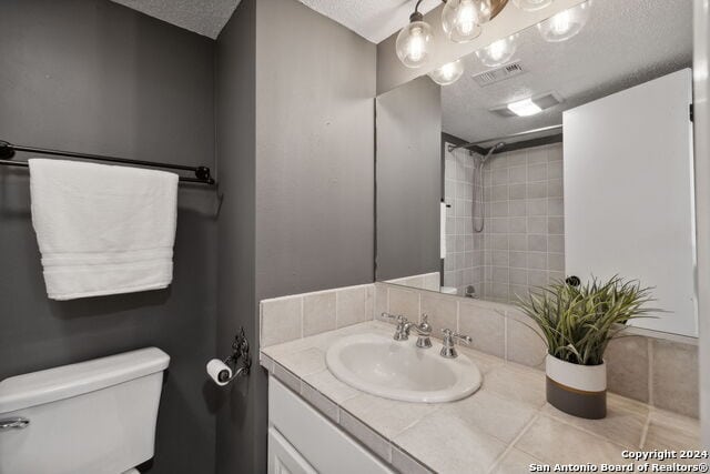 2918 Ranch Road 620th Rd N Unit C122, Austin, TX 78734 - bathroom with a textured ceiling, toilet, vanity, and a shower