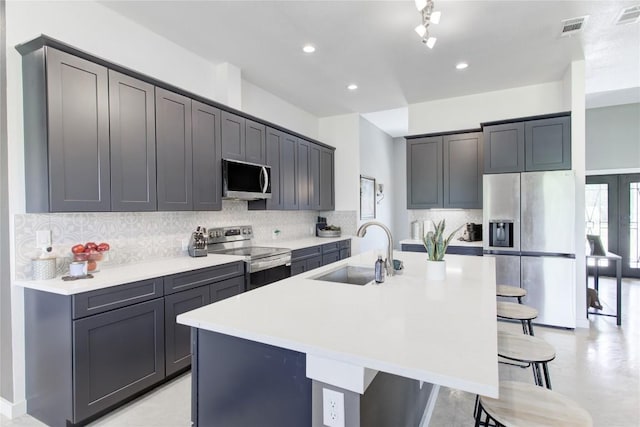 1215 Ridge Harbor Dr, Spicewood, TX 78669 - kitchen featuring appliances with stainless steel finishes, a sink, a breakfast bar, a center island with sink, and backsplash