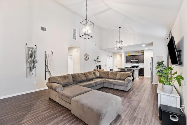 208 Shiner Ln, Georgetown, TX 78626 - living room featuring wood finished floors, baseboards, a chandelier, and high vaulted ceiling