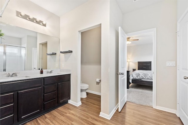 208 Shiner Ln, Georgetown, TX 78626 - ensuite bathroom featuring wood finished floors, toilet, a stall shower, and baseboards