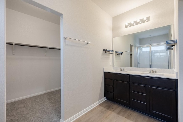 208 Shiner Ln, Georgetown, TX 78626 - full bath with a stall shower, double vanity, a spacious closet, and wood finished floors