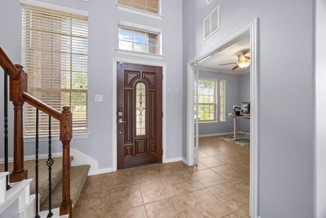 2817 Dusty Chisolm Trl, Pflugerville, TX 78660 - foyer entrance featuring stairs, baseboards, light tile patterned floors, crown molding, and ceiling fan