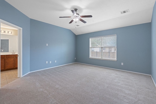 11117 Boundless Valley Dr, Austin, TX 78754 - spare room featuring light carpet, ceiling fan, baseboards, and vaulted ceiling