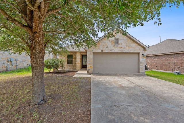 11117 Boundless Valley Dr, Austin, TX 78754 - view of front of house featuring an attached garage, concrete driveway, and stone siding
