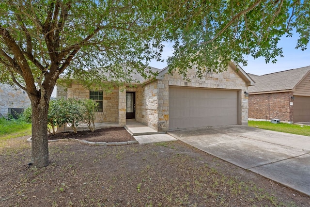 11117 Boundless Valley Dr, Austin, TX 78754 - view of front of home featuring stone siding, an attached garage, and concrete driveway