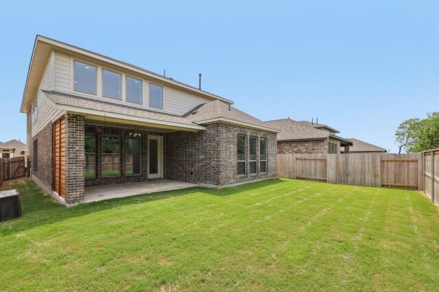 125 Bauer Loop, Liberty Hill, TX 78642 - rear view of property with brick siding, a fenced backyard, and a patio area