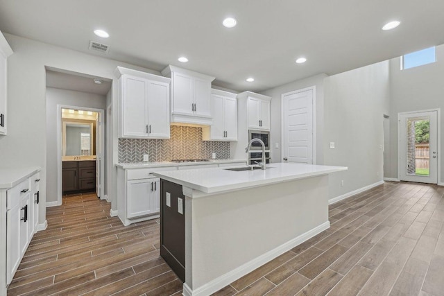 125 Bauer Loop, Liberty Hill, TX 78642 - kitchen with wood finished floors, cooktop, light countertops, white cabinets, and recessed lighting