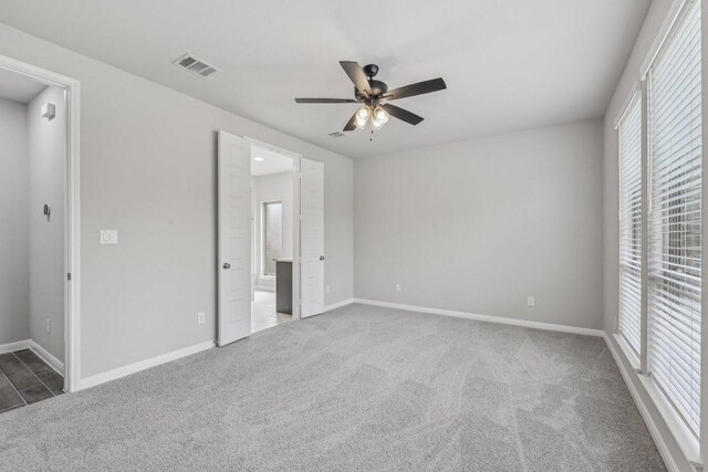 125 Bauer Loop, Liberty Hill, TX 78642 - unfurnished bedroom with multiple windows, carpet, and connected bathroom
