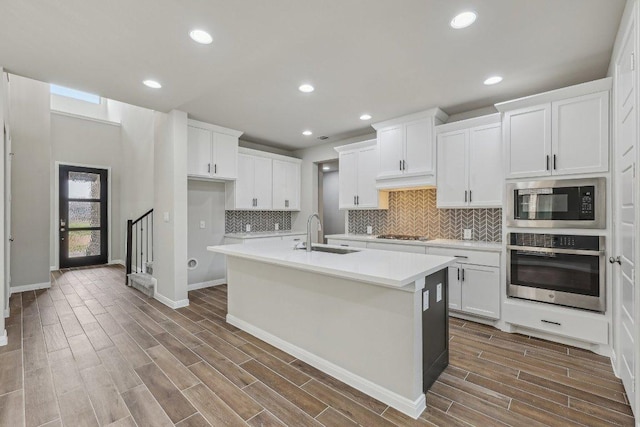 125 Bauer Loop, Liberty Hill, TX 78642 - kitchen featuring stainless steel oven, black microwave, dark wood-type flooring, light countertops, and decorative backsplash