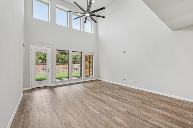 125 Bauer Loop, Liberty Hill, TX 78642 - unfurnished living room with a ceiling fan, a towering ceiling, and wood finished floors