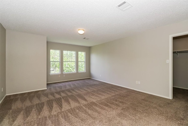 501 Thicket Ln, Kyle, TX 78640 - unfurnished bedroom featuring carpet floors, a spacious closet, a textured ceiling, baseboards, and a closet