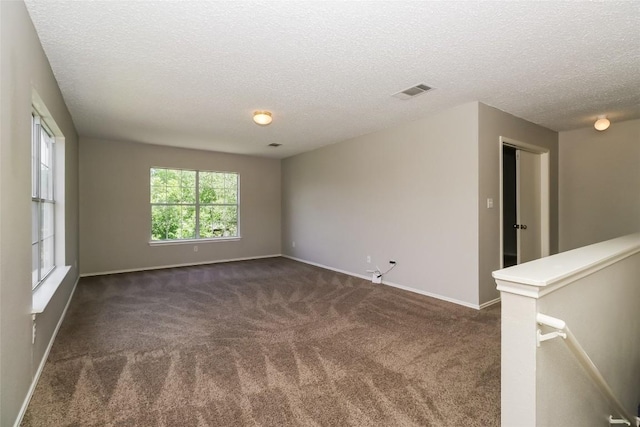 501 Thicket Ln, Kyle, TX 78640 - spare room featuring dark colored carpet, a textured ceiling, and baseboards