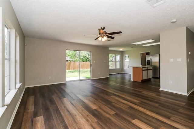 501 Thicket Ln, Kyle, TX 78640 - unfurnished living room with dark wood-style floors, a ceiling fan, a textured ceiling, and baseboards