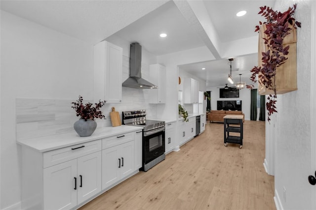 776 Butcher St, New Braunfels, TX 78130 - kitchen with electric stove, wall chimney exhaust hood, white cabinetry, light wood-style floors, and recessed lighting