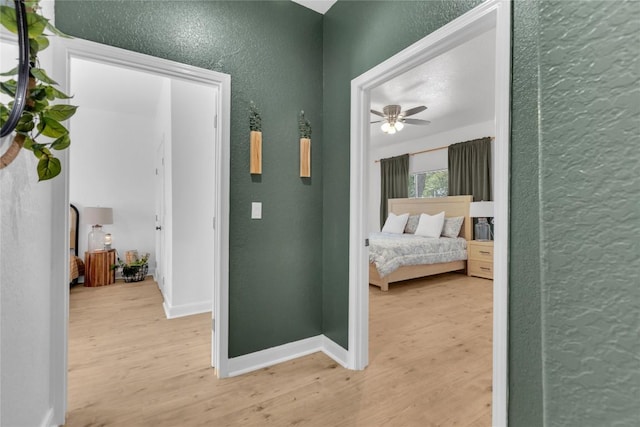 776 Butcher St, New Braunfels, TX 78130 - hallway with a textured wall, light wood-style flooring, and baseboards