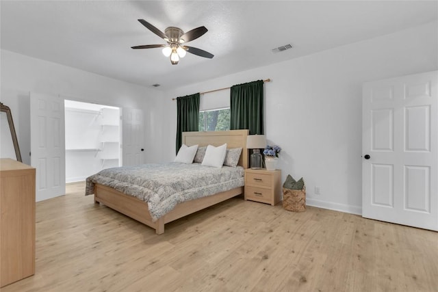 776 Butcher St, New Braunfels, TX 78130 - bedroom with wood finished floors, baseboards, a spacious closet, a ceiling fan, and a closet