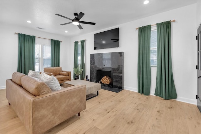 776 Butcher St, New Braunfels, TX 78130 - living room featuring light wood-type flooring, a ceiling fan, baseboards, recessed lighting, and a premium fireplace