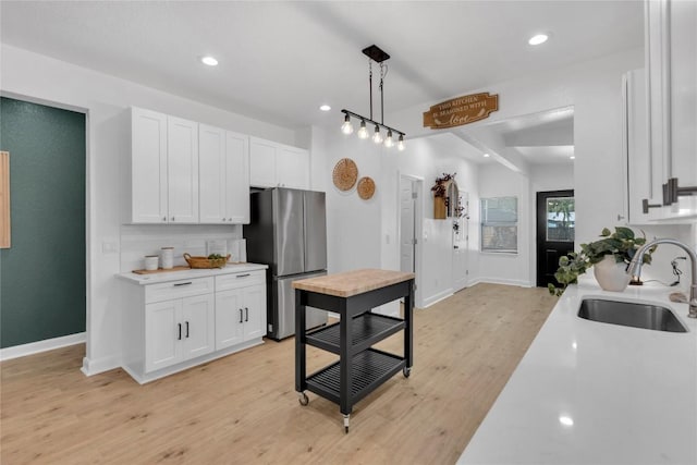 776 Butcher St, New Braunfels, TX 78130 - kitchen with a sink, freestanding refrigerator, light countertops, white cabinetry, and recessed lighting