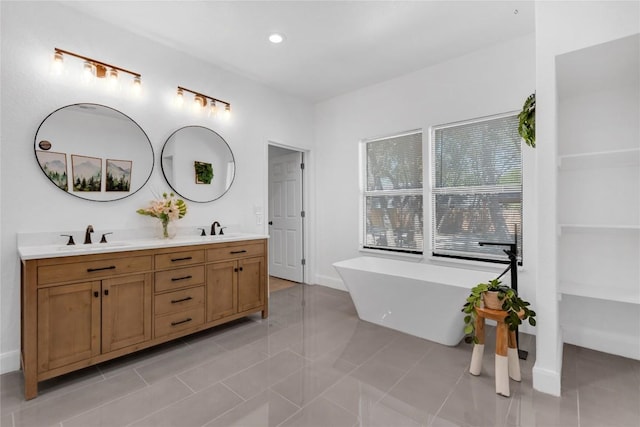 776 Butcher St, New Braunfels, TX 78130 - full bathroom with a freestanding tub, double vanity, recessed lighting, baseboards, and tile patterned flooring