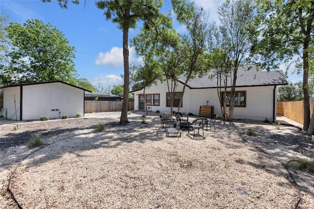 776 Butcher St, New Braunfels, TX 78130 - back of house with a fenced backyard, an outdoor fire pit, a patio, and an outbuilding