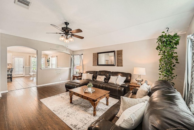 134 Sassafras St, Hutto, TX 78634 - living room featuring arched walkways, baseboards, ceiling fan, and dark wood-type flooring
