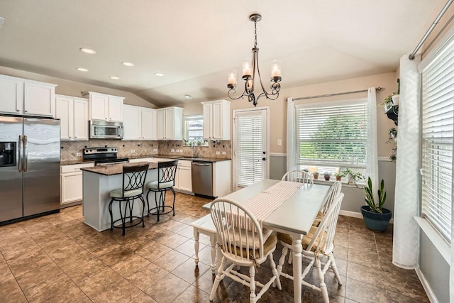 134 Sassafras St, Hutto, TX 78634 - tiled dining room featuring lofted ceiling, plenty of natural light, a chandelier, a sink, and recessed lighting