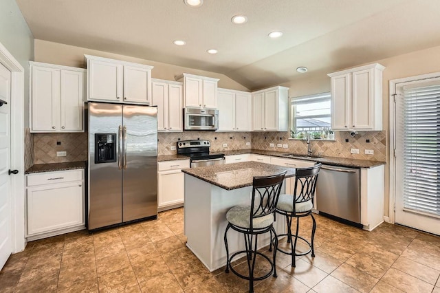 134 Sassafras St, Hutto, TX 78634 - kitchen with appliances with stainless steel finishes, a sink, lofted ceiling, a center island, and white cabinetry