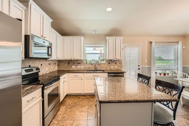 134 Sassafras St, Hutto, TX 78634 - kitchen featuring stainless steel appliances, a sink, a kitchen bar, a center island, and backsplash