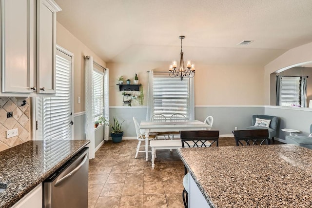 134 Sassafras St, Hutto, TX 78634 - dining space with a chandelier, vaulted ceiling, arched walkways, and light tile patterned floors